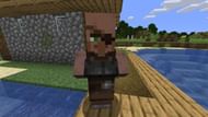 A weaponsmith villager standing near a village (Image via Minecraft)
